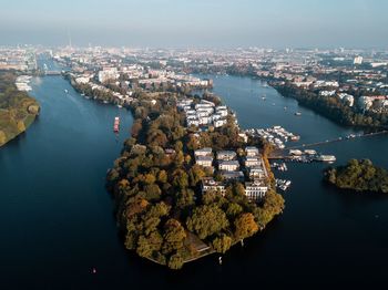 Aerial view of river amidst cityscape against sky