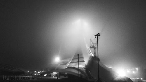 Low angle view of illuminated bridge against sky at night