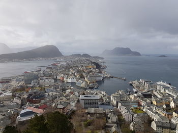 High angle view of city by sea against sky