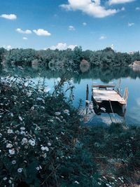 Boat moored in lake against sky