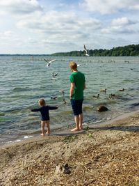 Full length of boy and man in water