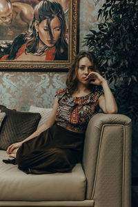 Portrait of young woman sitting on sofa