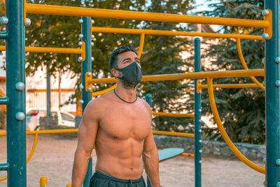 Young man wearing mask exercising outdoors