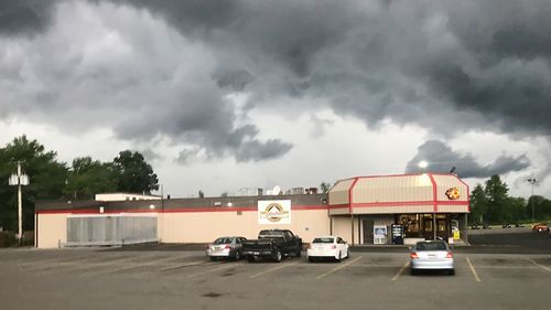 Car on road against storm clouds