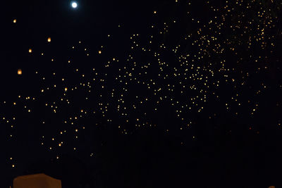 Low angle view of fireworks against sky at night