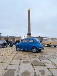 Vintage car on road against sky in city