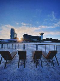 Chairs and tables against blue sky during winter