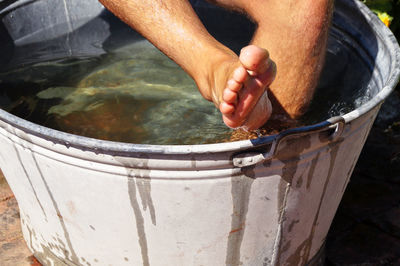 Low section of woman relaxing in bathtub