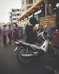Rear view of people sitting on road