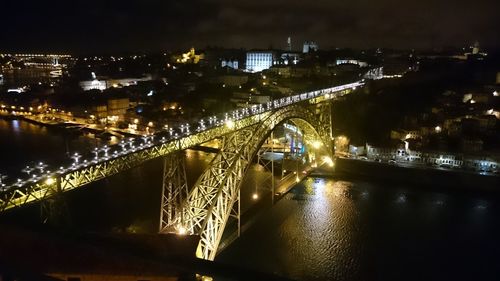 Illuminated bridge over river at night