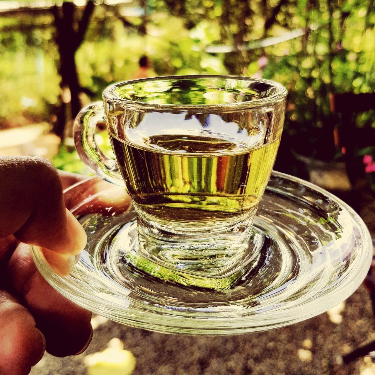 CLOSE-UP OF HAND HOLDING GLASS OF JUICE