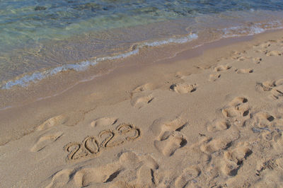 High angle view of footprints on sand at beach