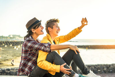 Lesbian couple taking selfie at beach