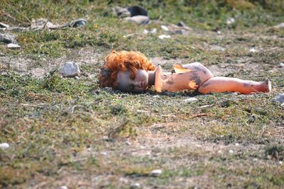 View of a broken doll toy lying on field