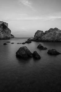 Rocks in sea against sky