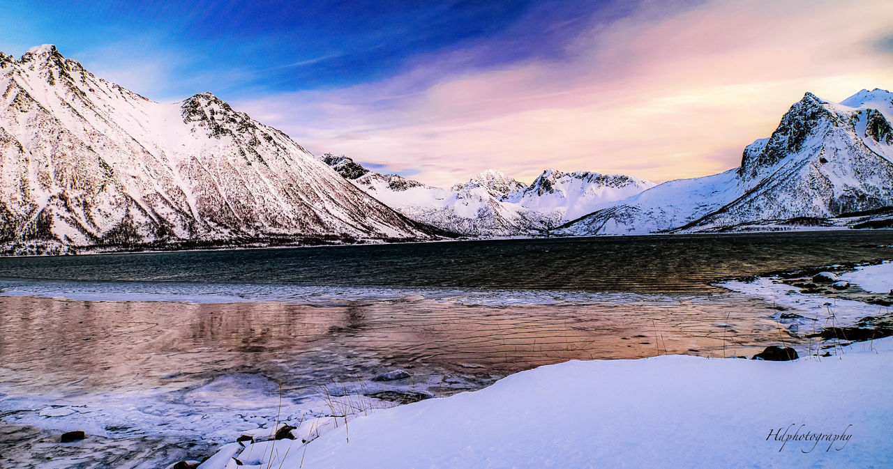 SCENIC VIEW OF LAKE AGAINST SNOWCAPPED MOUNTAINS DURING SUNSET