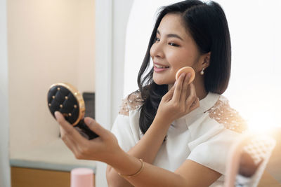 Smiling young woman holding wineglass