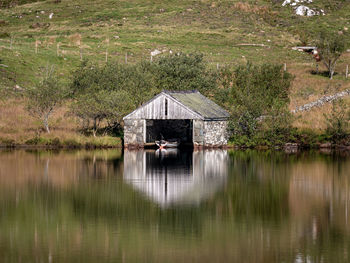 Hut by lake against building