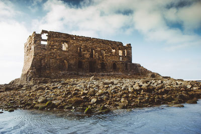 Low angle view of historical building against cloudy sky