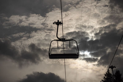 Low angle view of overhead cable car against sky