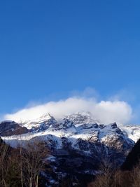 Scenic view of snowcapped mountains against blue sky