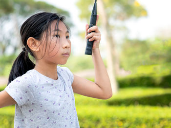 Girl looking away while playing badminton