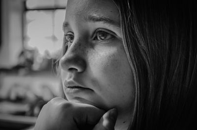 Close-up of girl at home with hand on chin