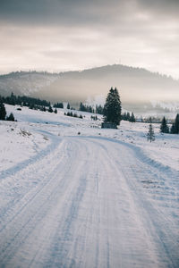Snow covered landscape against sky