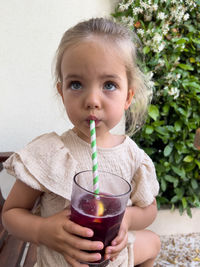 Portrait of young woman drinking glass