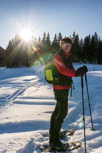 Man standing in snow against sky during winter