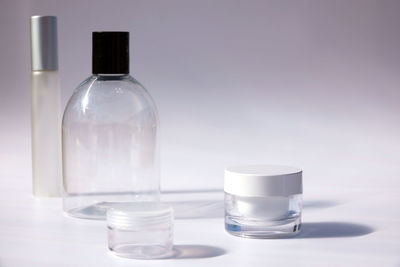 Close-up of glass bottle on table against white background