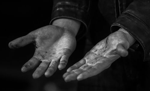 Midsection of man hand against black background