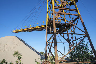 Low angle view of electricity pylon against clear sky