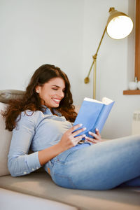 Young woman using mobile phone at home