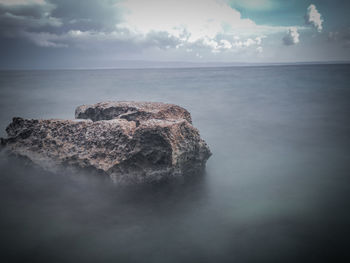 Rocks on sea shore against sky