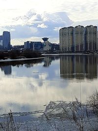 Bridge over river by buildings against sky in city