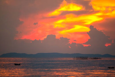 Scenic view of sea against dramatic sky during sunset