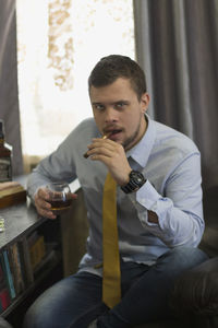 Man holding cigarette while sitting on table