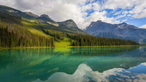 Scenic view of lake and mountains against cloudy sky