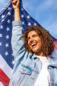 Happy beautiful woman holding usa flag celebrating independance us day