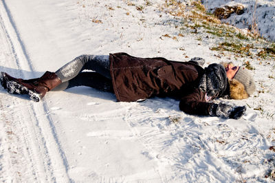 Low section of person with dog relaxing on floor