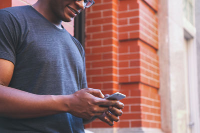 Midsection of man using mobile phone