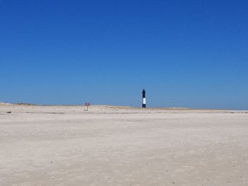 Scenic view of beach against clear blue sky