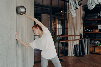 Woman exercising by wall at health club