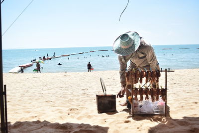 Fisherman grilling cuttlefish on beach