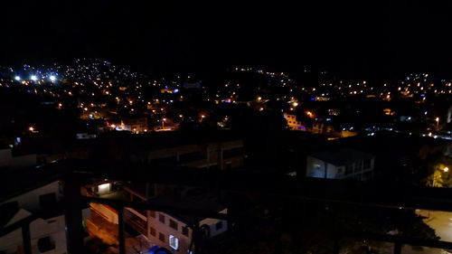 Illuminated city against sky at night