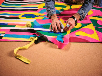 An artist works on a giant cloth tapestry in the their art studio.