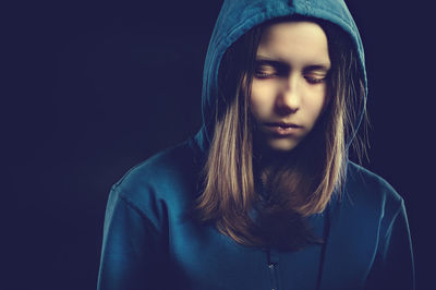 Close-up of beautiful young woman over black background