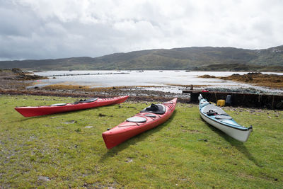 Boats moored on lake against sky