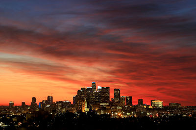 Illuminated buildings against sky during sunset